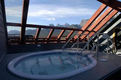 a hot tub on a balcony with a view of the mountains at Apartment 411, Antique Heritage in Canmore
