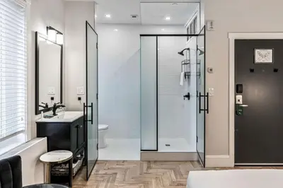 a bathroom with a shower and a sink and a toilet at The Inn on Officers' Garden in Calgary