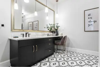 a bathroom with a black vanity and a mirror at The Inn on Officers' Garden in Calgary