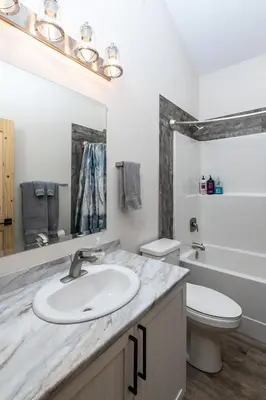 a white bathroom with a sink and a toilet at Lazy Moose in Valemount