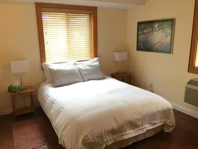 a bedroom with a white bed and a window at All Seasons Bed & Breakfast in Kelowna