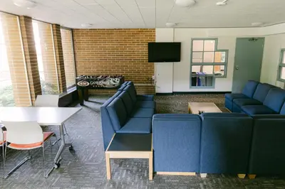 a waiting room with blue couches and a table at Pacific Spirit Hostel in Vancouver