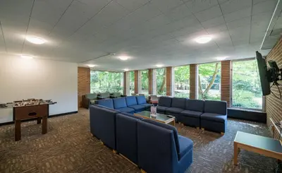 a waiting room with blue chairs and a table at Pacific Spirit Hostel in Vancouver