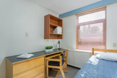 a bedroom with a desk and a bed and a bed at Pacific Spirit Hostel in Vancouver