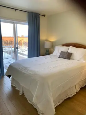 a bedroom with a large white bed with a window at Sonora Desert Inn in Osoyoos