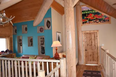 a living room with blue walls and a wooden ceiling at Seven Sisters Mountains House in Kitwanga
