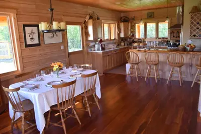 a dining room with a table and chairs in a kitchen at Seven Sisters Mountains House in Kitwanga