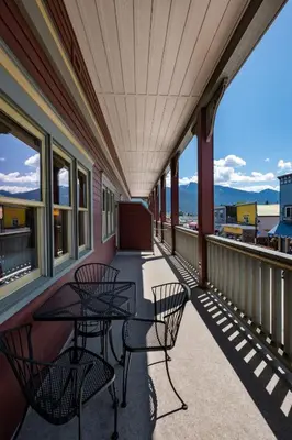 a balcony with tables and chairs on a building at Kaslo Hotel in Kaslo