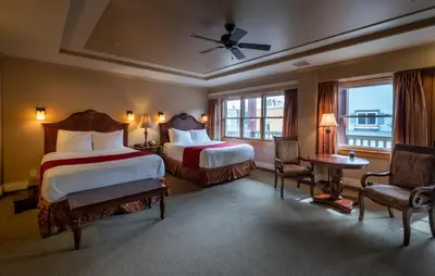 a hotel room with two beds and a table and chairs at Kaslo Hotel in Kaslo