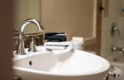 a bathroom sink with a faucet and towels on it at Kaslo Hotel in Kaslo