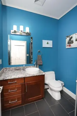 a blue bathroom with a toilet and a sink at Lily glacier suite at silver bear condos in Revelstoke