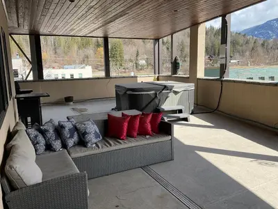 a couch with red and blue pillows on a patio at Lily glacier suite at silver bear condos in Revelstoke