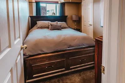 a bedroom with a large bed with a wooden frame at The Hidden Hollow Suite - Downtown in Drumheller