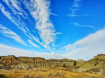 a view of the badlands under a blue sky at The Hidden Hollow Suite - Downtown in Drumheller