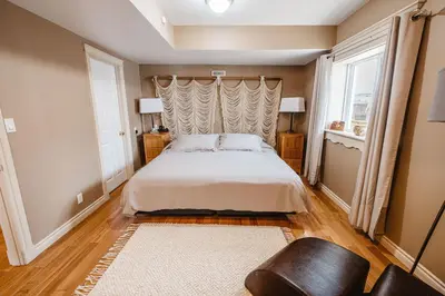 a bedroom with a bed and a window at The Watermark Suite - Downtown in Drumheller
