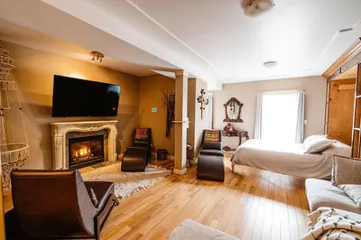 a living room with a fireplace and a bed at The Watermark Suite - Downtown in Drumheller