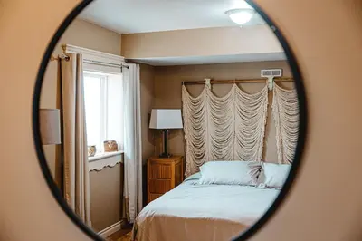 a bedroom with a bed and a mirror at The Watermark Suite - Downtown in Drumheller