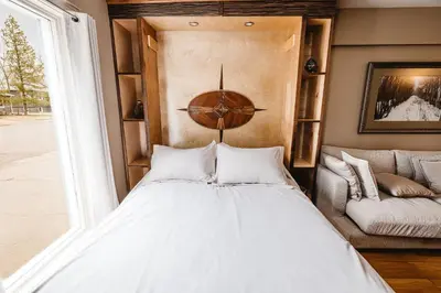 a bedroom with a bed and a couch at The Watermark Suite - Downtown in Drumheller