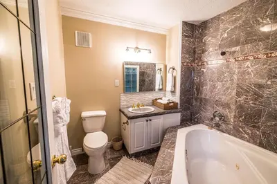 a bathroom with a tub and a toilet and a sink at The River Blossom Suite - Downtown in Drumheller