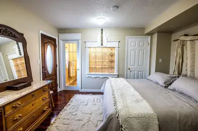 a bedroom with a bed and a dresser and a window at The River Blossom Suite - Downtown in Drumheller