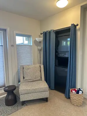 a living room with a chair and a television at K STREET CARRIAGE HOUSE Studio in Penticton