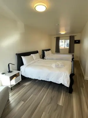 a bedroom with two beds and a table with a lamp at Destination INN in Radium Hot Springs