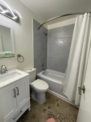 a white bathroom with a toilet and a sink and a tub at Destination INN in Radium Hot Springs
