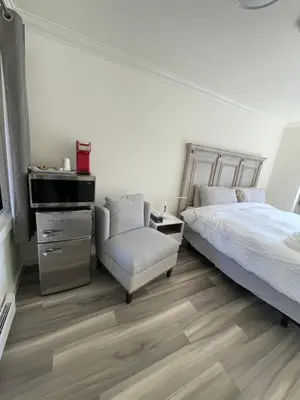 a bedroom with a bed and a chair and a sink at Destination INN in Radium Hot Springs