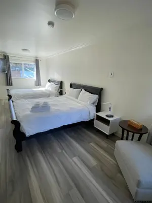a bedroom with two beds and a couch at Destination INN in Radium Hot Springs