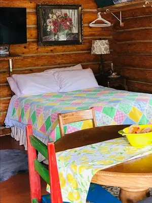 a bedroom with a bed and a table with a bowl of fruit on it at Jade Fever Cabina in Jade City
