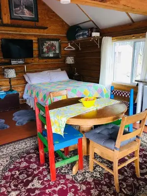 a bedroom with a table and chairs and a bed at Jade Fever Cabina in Jade City