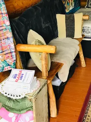 a living room with a wooden chair and a couch at Jade Fever Cabina in Jade City