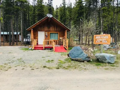 a small log cabin with a sign in front of it at Jade Fever Cabina in Jade City