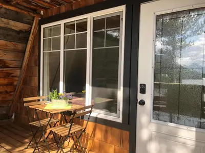 a porch with a table and a glass door at Cooks and Puppies Hideaway in Jade City