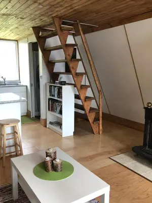 a living room with a staircase and a table at Cooks and Puppies Hideaway in Jade City