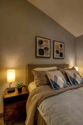 a bedroom with a bed and a table with a lamp at Beautiful Newly Reno 2BDM 2 Bth Sleep up to 6 Adults & Kids Mountain View Townhouse Suite in Canmore