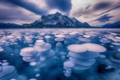 a large body of ice with a mountain in the background at Beautiful Newly Reno 2BDM 2 Bth Sleep up to 6 Adults & Kids Mountain View Townhouse Suite in Canmore