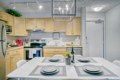 a kitchen with a white table with chairs and a refrigerator at Cozy 2 BR - King and Queen Condo Sleep up to 6 for WFH & Vacation in Canmore