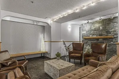 a waiting room with a couch and chairs and a screen at Cozy 2 BR - King and Queen Condo Sleep up to 6 for WFH & Vacation in Canmore