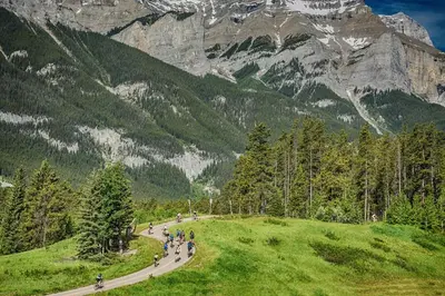 a group of people walking down a road in the mountains at Cozy 2 BR - King and Queen Condo Sleep up to 6 for WFH & Vacation in Canmore