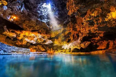 a cave with a blue pool of water in it at Cozy 2 BR - King and Queen Condo Sleep up to 6 for WFH & Vacation in Canmore