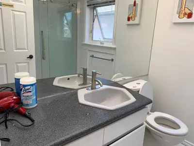 a bathroom with a sink and a toilet at One Bedroom queen bed Sharing Washroom in Tiger Sweet House License## in Richmond