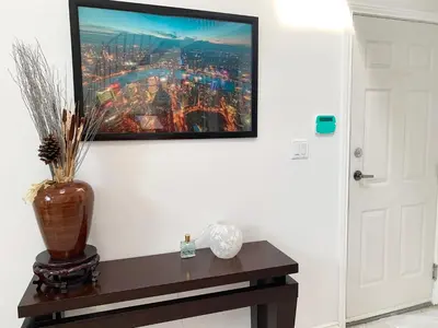 a vase on a table with a picture on the wall at One Bedroom queen bed Sharing Washroom in Tiger Sweet House License## in Richmond