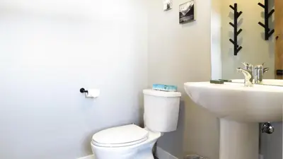 a bathroom with a white toilet and a sink at Echo Landing #22 by Bear Country in Sun Peaks