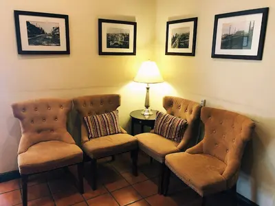 a room with two chairs and a lamp on a table at The Met Hotel in New Westminster