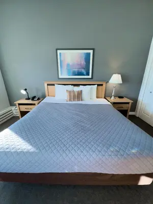 a bedroom with a large bed and two night stands at The Met Hotel in New Westminster