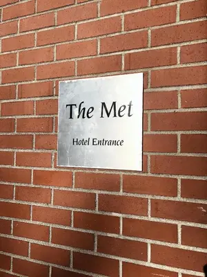 a sign on a brick wall that reads the met at The Met Hotel in New Westminster