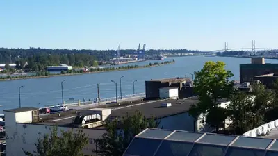 a view of a river with a bridge in the background at The Met Hotel in New Westminster