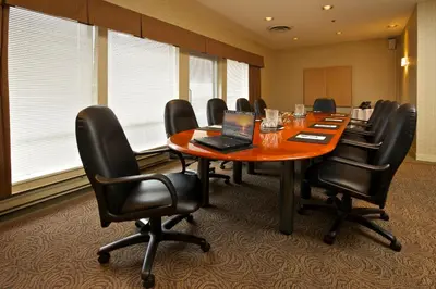 a conference room with a table and chairs and a laptop at Coast Tsawwassen Inn in Delta