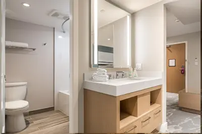 a bathroom with a sink and a toilet and a mirror at Coast Tsawwassen Inn in Delta